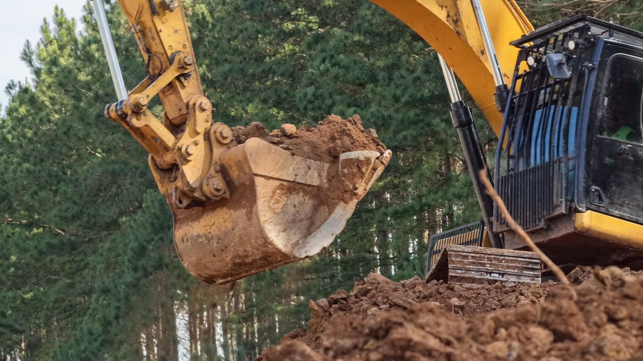 Detalhe da caçamba de escavadeira com basalto extraído da jazida